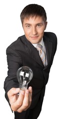 Young handsome business man holding light bulb isolated on white