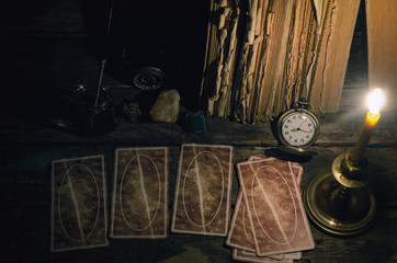 Tarot cards on fortune teller table in the lights of burning candle background. Futune reading concept. Divination.