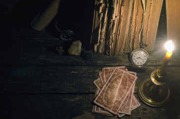 Tarot cards on fortune teller table in the lights of burning candle background. Futune reading...
