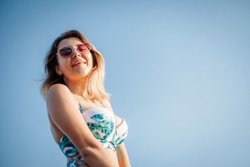 Portrait of a smiling happy young woman in bikini and sunglasses at sea in travel. concept of relaxation, recreation.