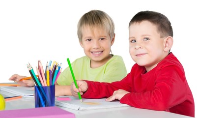 Two Smiling School Children Drawing on Notebooks