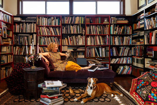 Woman with dog sitting on sofa at home