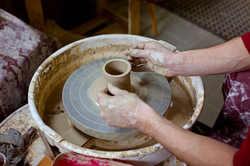 руки гончара, создающего вазу
