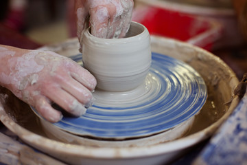 hands of potter creating jar on a circle