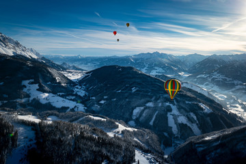 Heissluftballone über den winterlichen Alpen