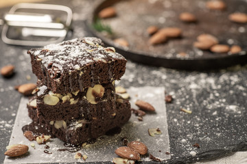 A stack of chocolate brownies on dark plat background ,homemade bakery and dessert.