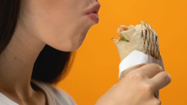 Woman greedily eating pita burger, bulimia problems, unhealthy fast food meal