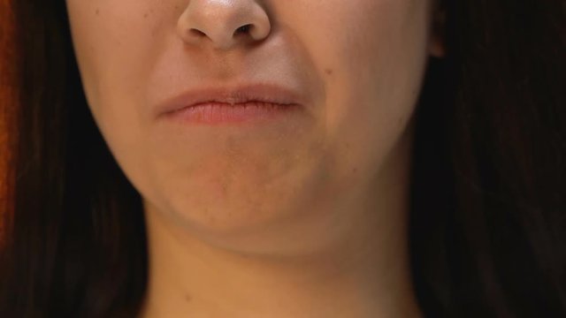 Woman eating hamburger with disgust, refusing unhealthy junk food, close up