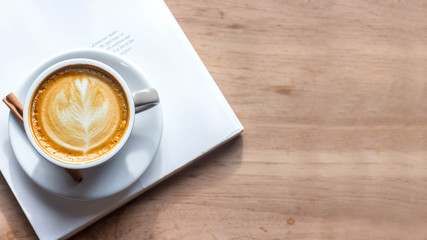 i often read books in the morning with coffee cup favorite. Cup of Coffee latte' art with a book in Coffee shop. Noise, Retro, Vintage, top view.