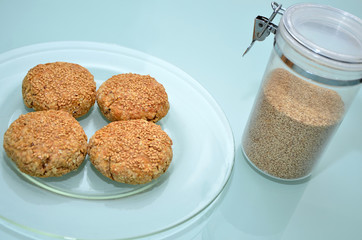 Vier selbstgebackene Vollkornbrötchen mit Sesam auf Glasteller