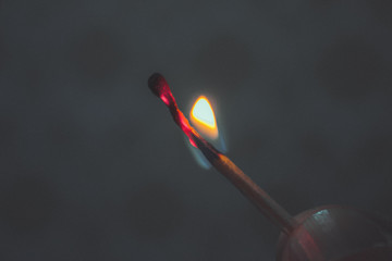 Burning match on black background