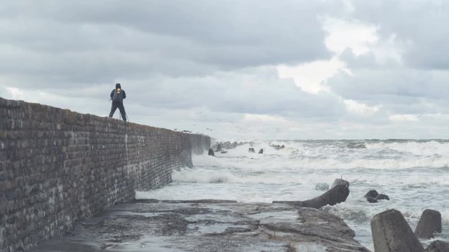A photographer takes pictures of the sea storm.