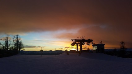 Fototapeta premium St. Oswald, Austria, Carinthia - December 9, 2018: Captured the silhouette of a lift station on the top of a mountain in St. Oswald, Austria, Carinthia, in the sunset.during a hiking.