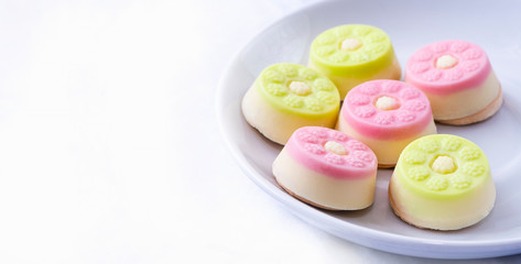 White chocolate candies on a white plate. Confectionery on a white background.