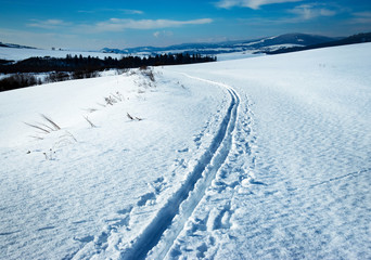 snowy winter landscape with cross country ski path