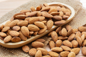 almond nuts on wooden plate.