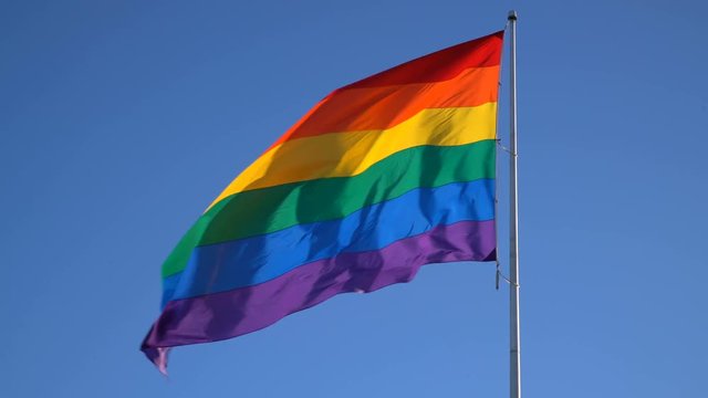 LGBT Gender Equality Symbol Rainbow Flag Waiving in Blue Sky -Long Shot-
