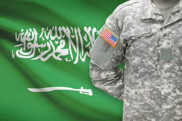 Fototapeta premium American soldier with flag on background - Saudi Arabia