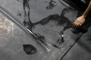Scenic imprint of the dancer's back on a dark dance floor.