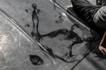 Scenic imprint of the dancer's back on a dark dance floor.