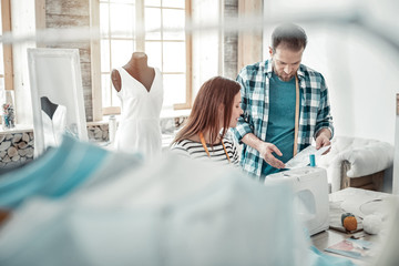 Obraz premium Couple of fashion designers working in their modern light studio