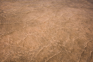 Pattern of small sea waves shining in sunlight