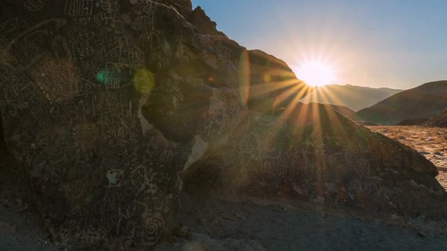 Timelapse Tracking Shot of Sunrise Illuminating Indian Petroglyphs -Tilt Up-