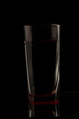 Glass with water on a dark colorful background