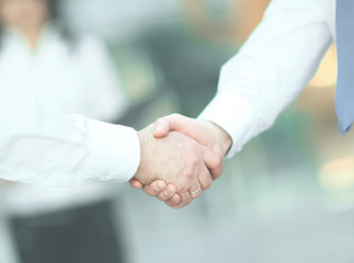 business handshake of employees on the background of the office.