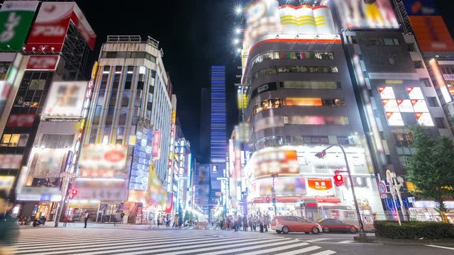 Timelapse of Busy Downtown Crosswalk at Night in Shinjuku, Front View -Pan Left-