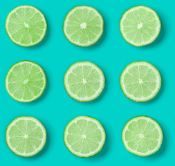 Fototapeta premium Fruit pattern of lime slices on blue background. Flat lay, top view.