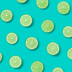 Obraz premium Fruit pattern of lime slices on blue background. Flat lay, top view.