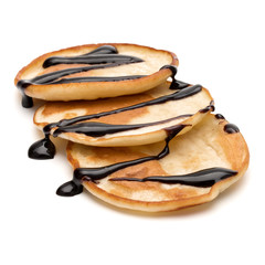 Three pancakes with chocolate syrup isolated on white background cutout.