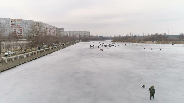 Aerial View Of River, Fishermen on Ice. Cloudy Winter Day. Energodar, Ukraine. 4K video
