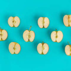 Fruit pattern of apple halves on blue background. Flat lay, top view. Food background.