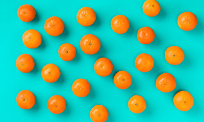 Fruit pattern of fresh mandarin on blue background. Flat lay, top view. Pop art design, creative summer concept. Citrus in minimal style.