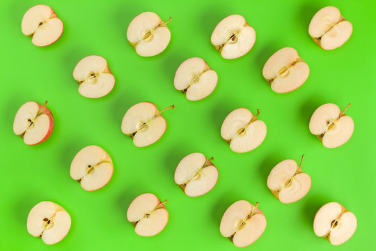 Fruit pattern on green background. Apple halves geometrical layout. Flat lay, top view. Food background.
