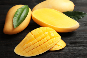 Ripe juicy mango on dark wooden table