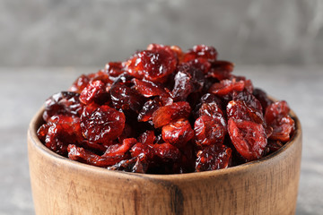 Bowl with sweet cranberries on table, closeup. Dried fruit as healthy snack