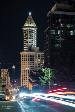 Neon Car Streaks on Seattle Streets with Lit Tower and Puget Sound at Night