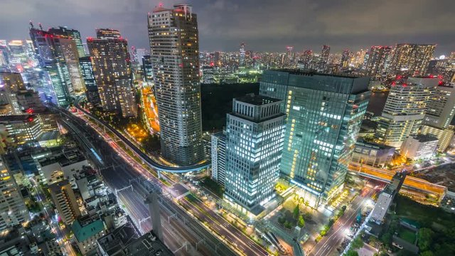 Timelapse Overview of City Transit below Tokyo Skyline at Night