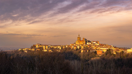 Fototapeta na wymiar Winter sunset in the Monferrato hills. Village of Camagna, Piedmont, Italy. Peaceful sight.