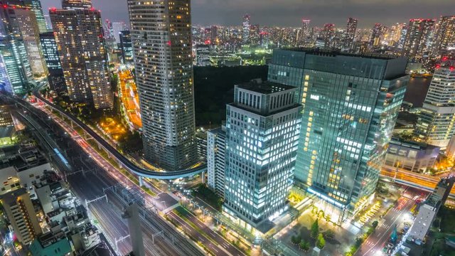 Timelapse Overview of City Transit below Tokyo Skyline at Night -Zoom Out-