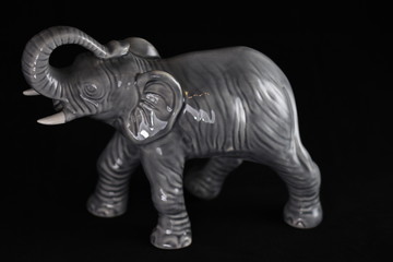 Fototapeta na wymiar gray porcelain elephant on a black background