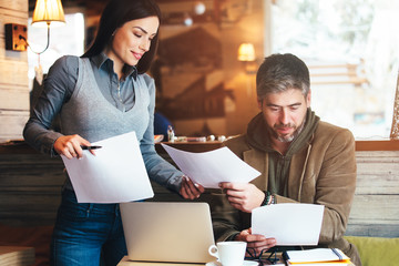 Man and woman in cafe discussing contract