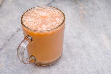 Teh tarik or pulled tea is a famous sweet milk tea in Malaysia. Bubble is floating on the surface of teh tarik.