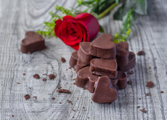 Bombones de chocolate en forma de corazón con flor roja
