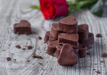 Bombones de chocolate en forma de corazón con flor roja