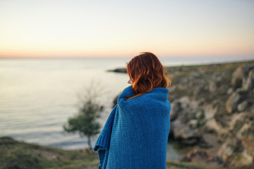 woman in a blanket on the sea evening