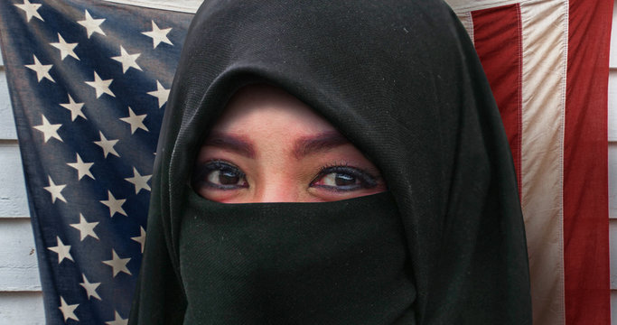 Beautiful Face Of Muslim Woman In Traditional Islam Burqa Or Burka Head Scarf Posing Cheerful And Happy Smiling Isolated On United States American Flag Background